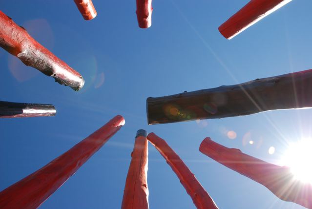 Seen from within, the tips of the Log Henge timber circle against the wide, blue Montana sky