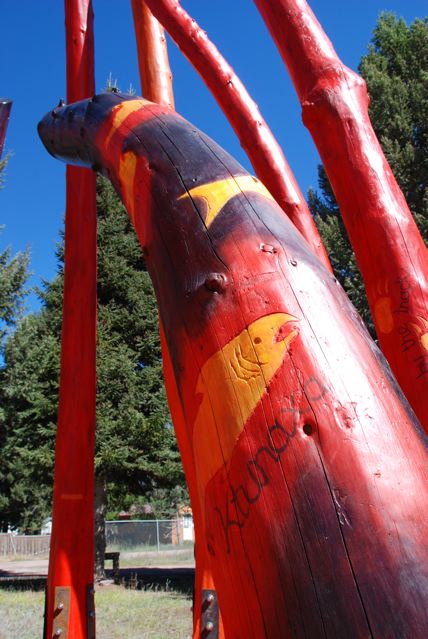 Log Henge detail showing Kootenai tribe name in the Kootenai language calligraphied by artist Jennifer Dyer and a pictogram of a local fish by artist Merrily Dunham